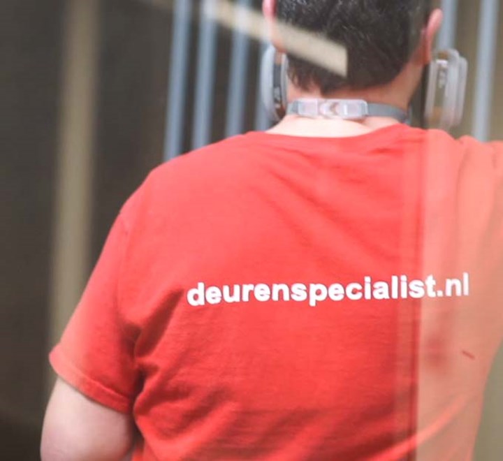 Logo van De Deurenspecialist op t-shirt van medewerker